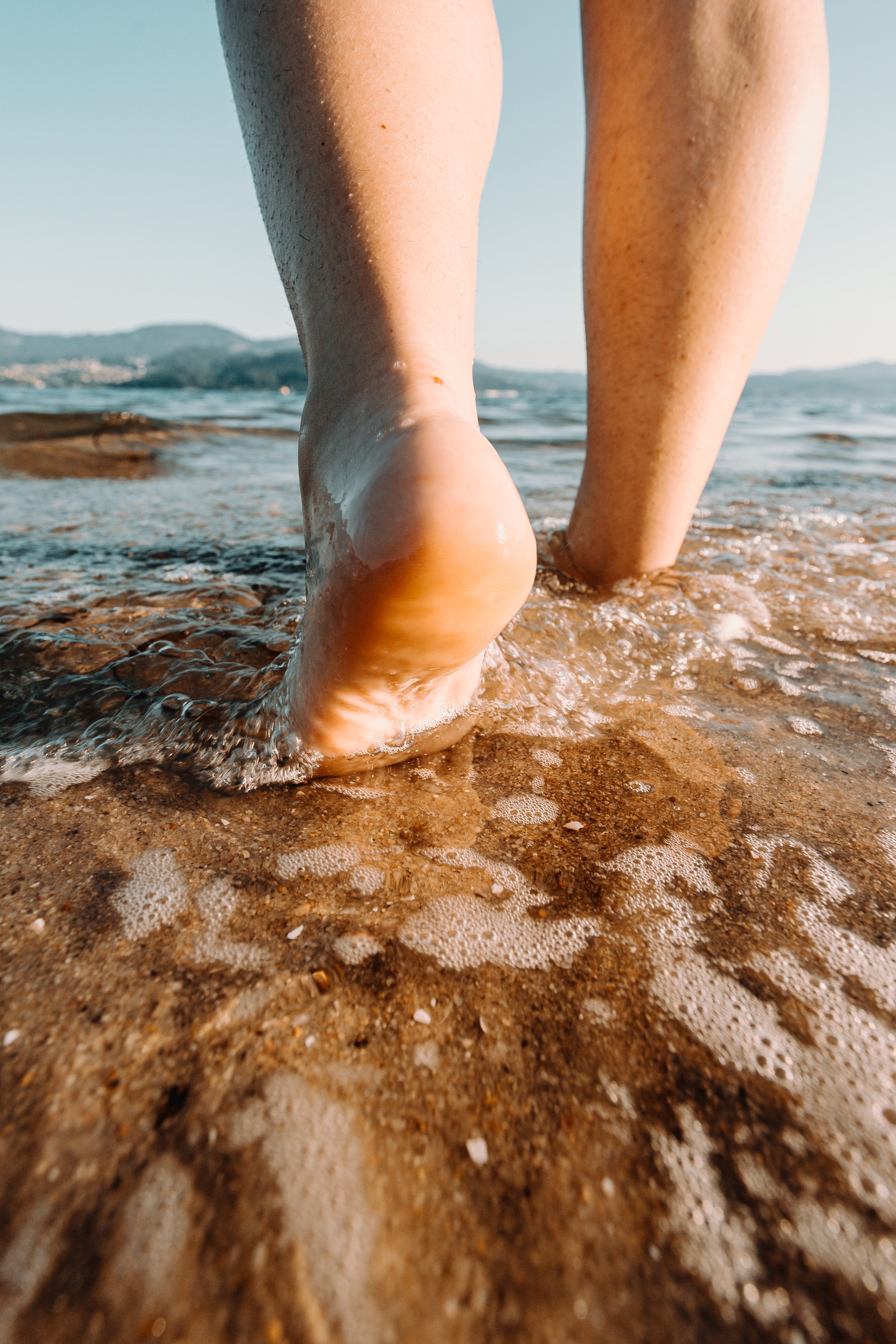 Smooth, healthy heels walking freely on the beach after using HYDR8 Sole Repair Cream